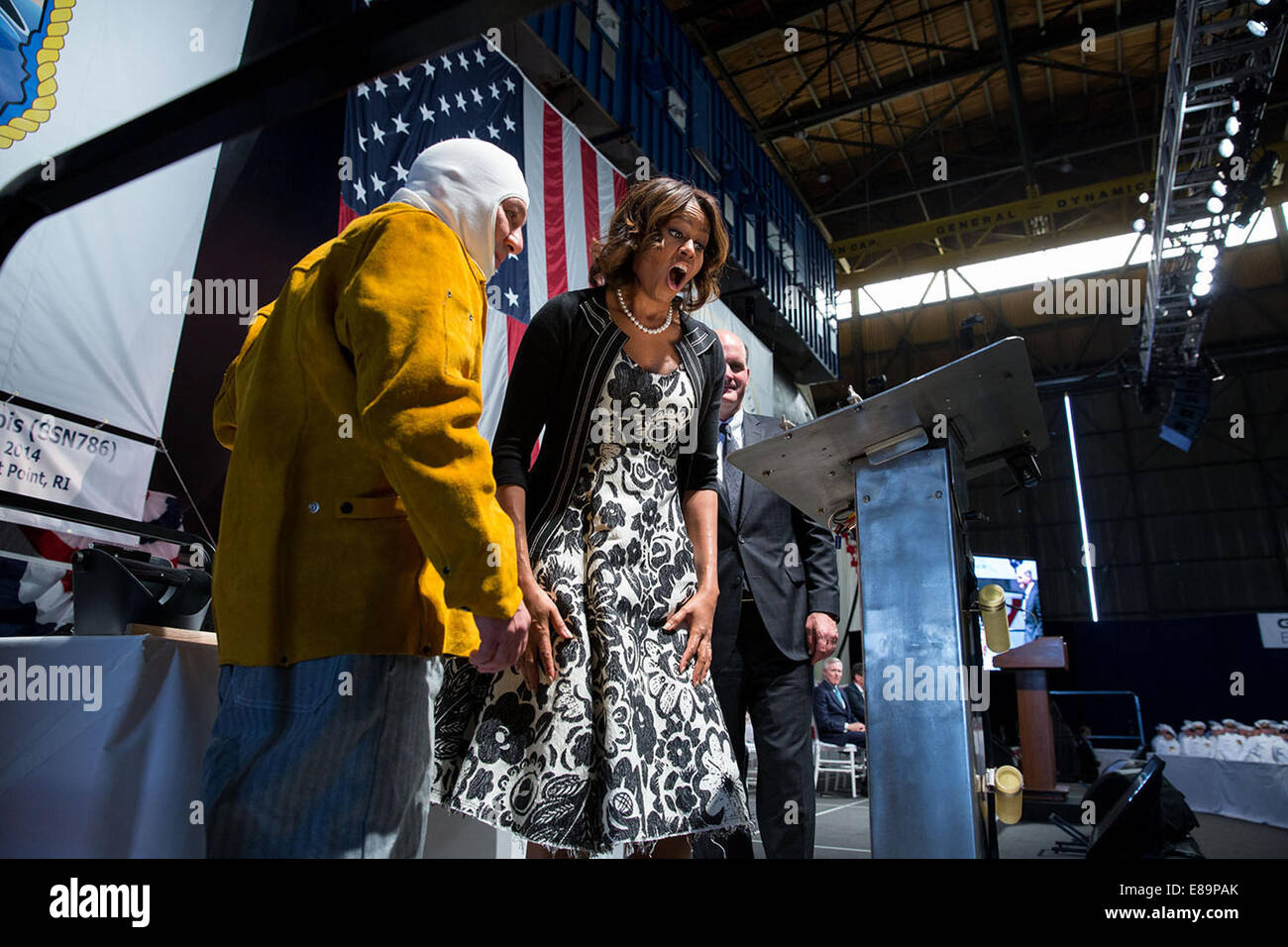 First Lady Michelle Obama reagiert auf ihre Initialen geschweißt auf einer Stahlplatte durch Schweißer Michael Macomber während einer Kiellegung Zeremonie für die USS Illinois der General Dynamics elektrische Boot Werft in North Kingston, RI, 2. Juni 2014 zu sehen. Stockfoto