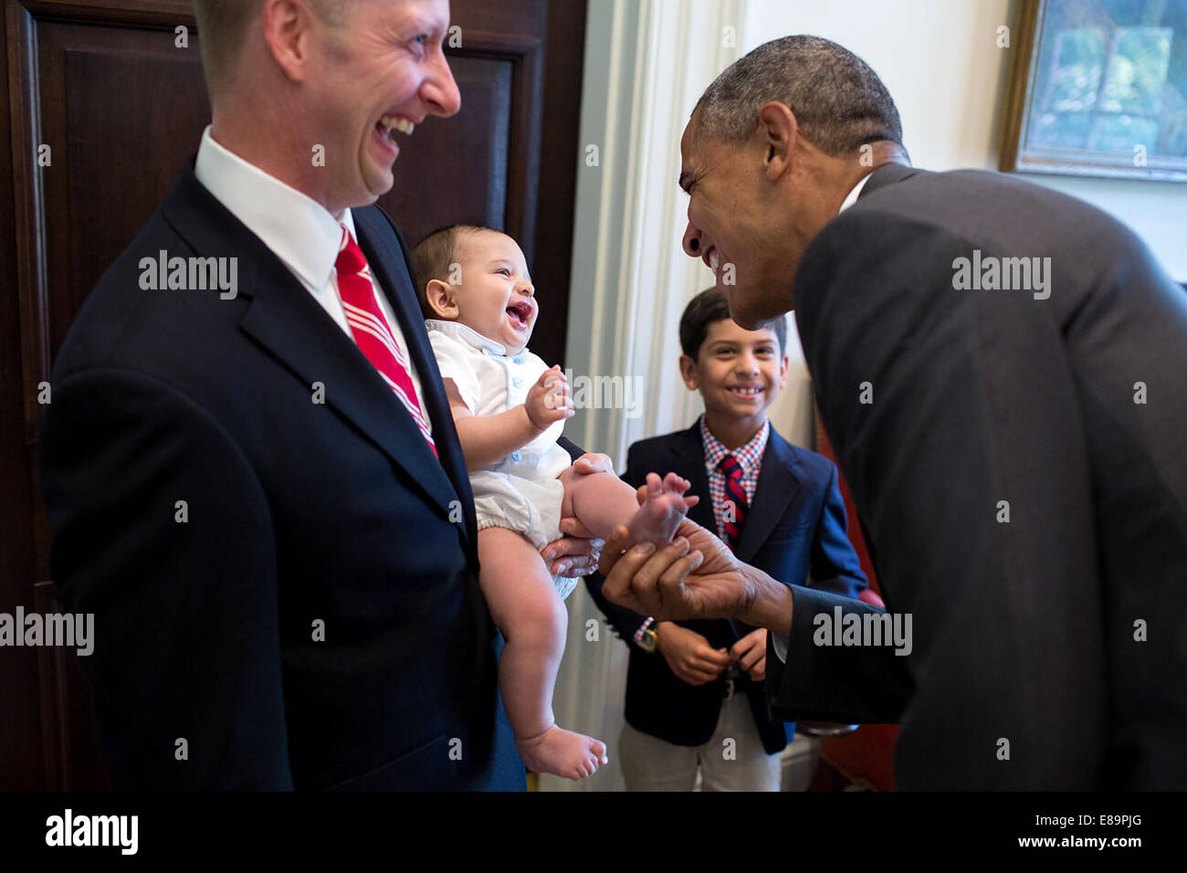 Präsident Barack Obama begrüßt die Familie der abfliegenden Mitarbeiter Archana Snyder, Council of Economic Advisers, in den äußeren Oval Office, 3. Juli 2014. Behandelnden sind: Scott Snyder, Ehepartner; Devan Snyder, Sohn (7 Jahre), Mira Snyder, Tochter (2 Jahre) und Dil Stockfoto