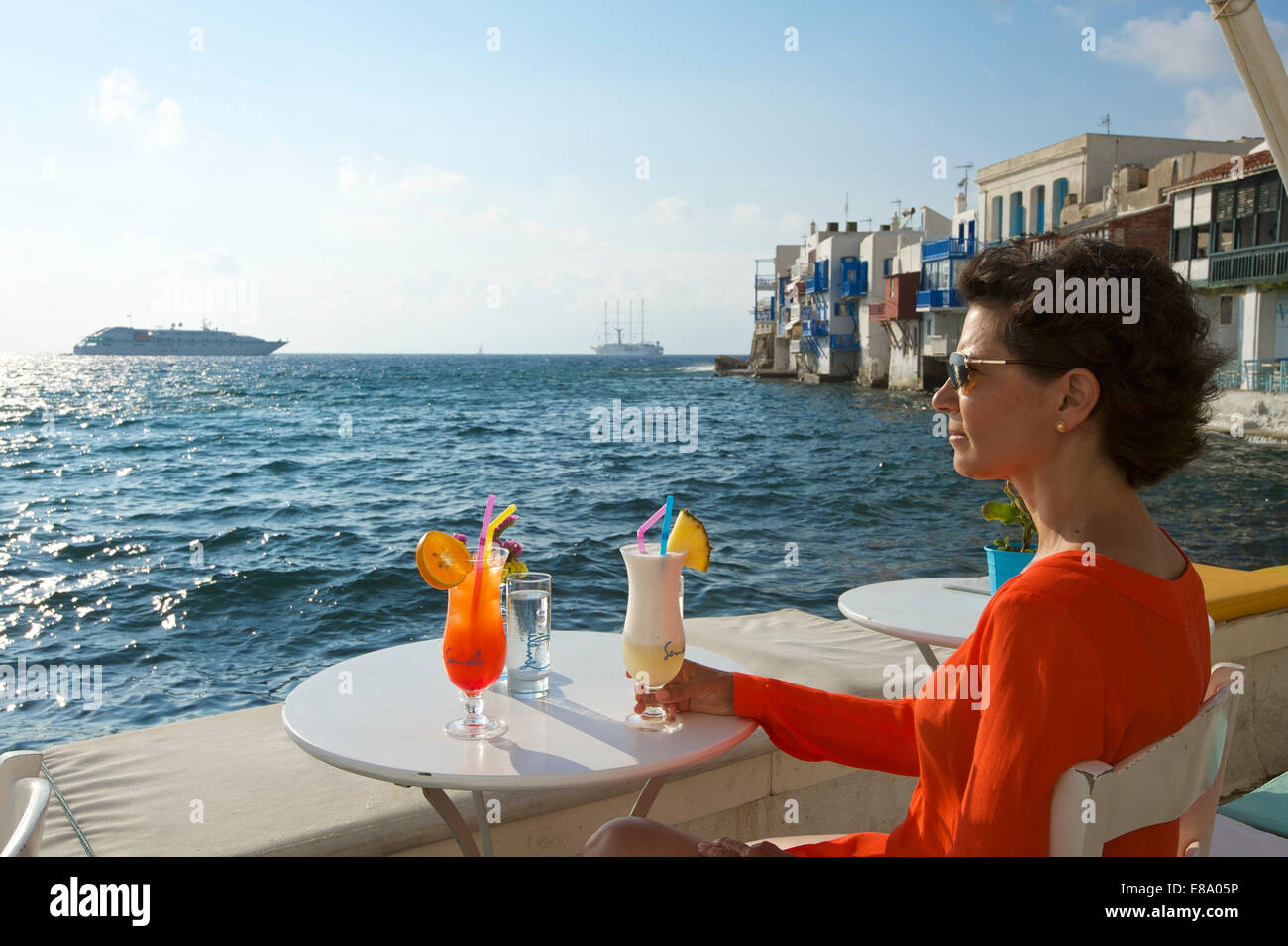 Frau, genießen Sie einen Cocktail und einen Blick über das Meer, klein-Venedig, Mykonos Stadt, Mykonos, Kykladen, Griechenland Stockfoto