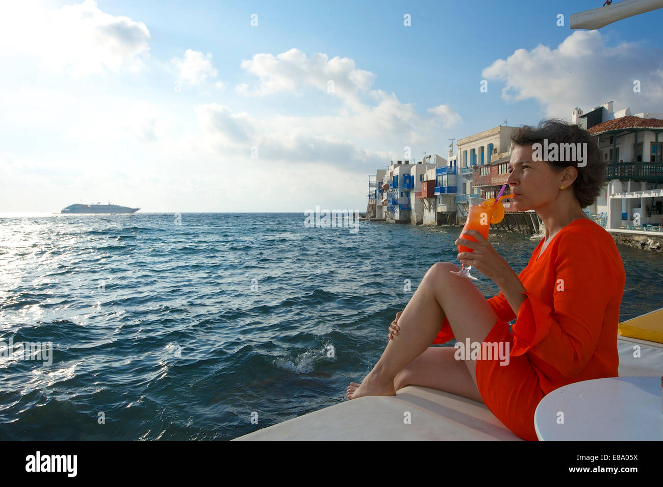 Frau, genießen Sie einen Cocktail und einen Blick über das Meer, klein-Venedig, Mykonos Stadt, Mykonos, Kykladen, Griechenland Stockfoto