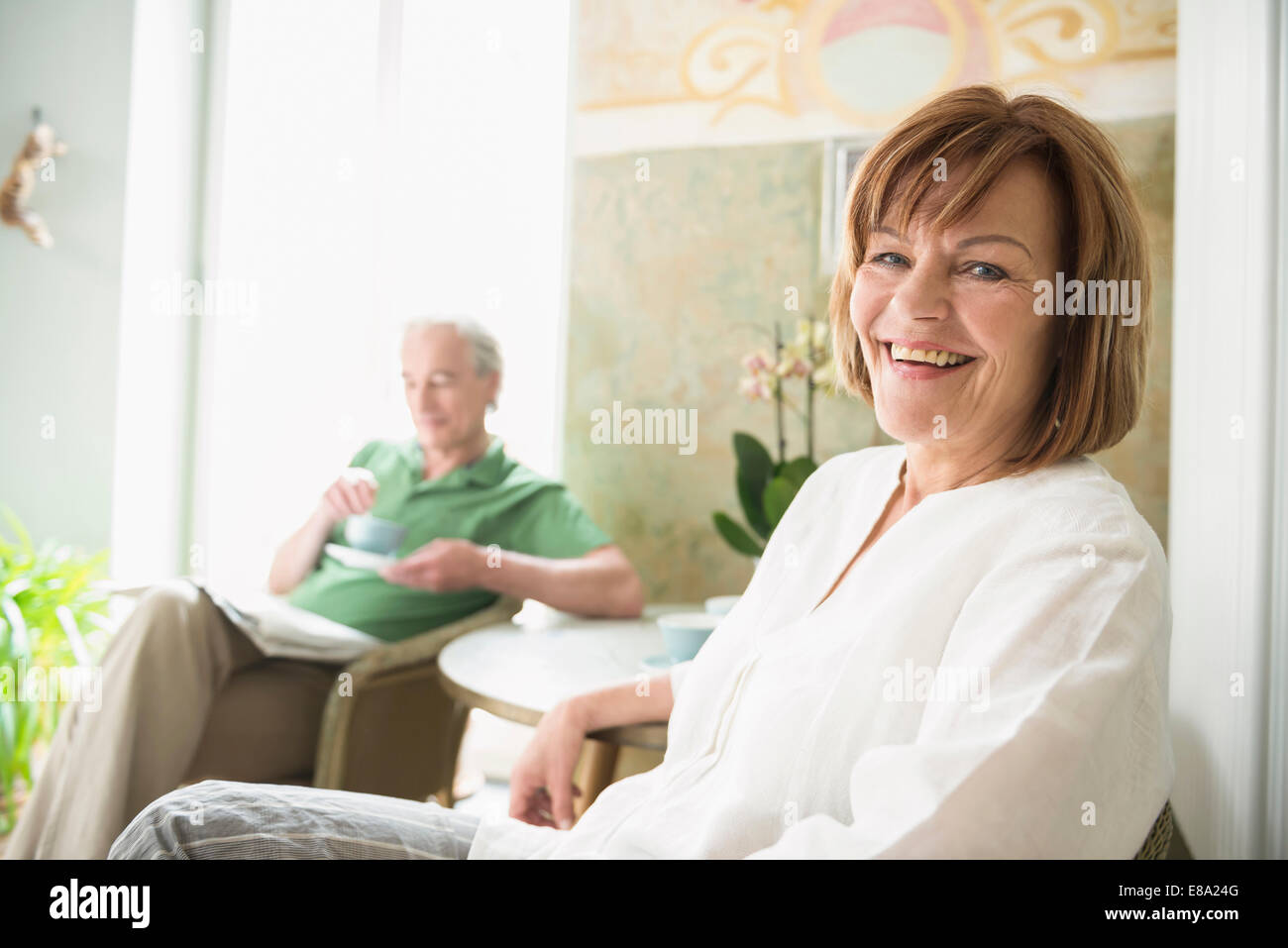 Porträt von senior Frau lächelnd während reifer Mann im Hintergrund Stockfoto