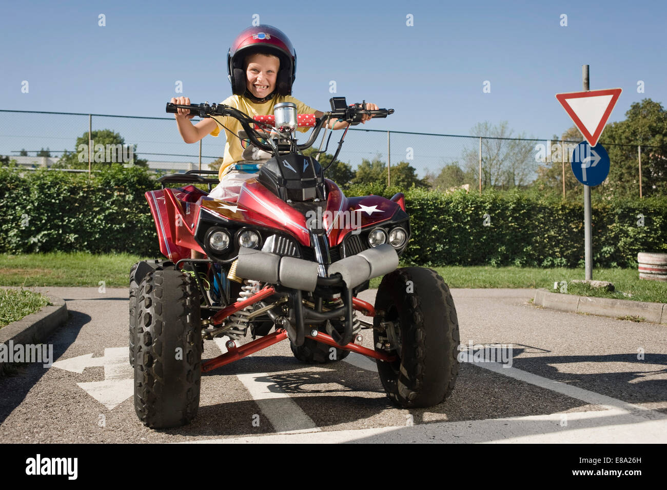 Fröhlicher Junge mit Quadbike auf Treiber-Truppenübungsplatz Stockfoto