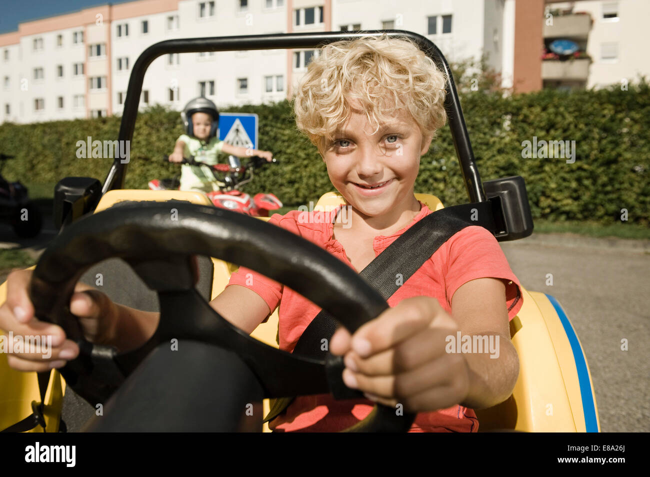 Lächelnde junge im Fahrzeug auf Treiber-Truppenübungsplatz Stockfoto