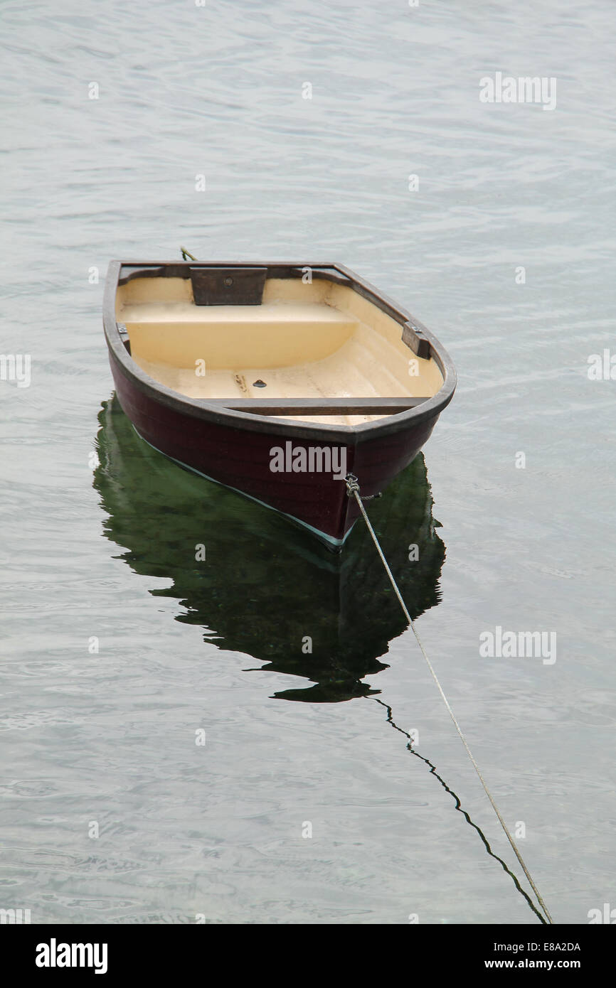 Ein kleines Ruderboot auf einem Seil angebunden. Stockfoto