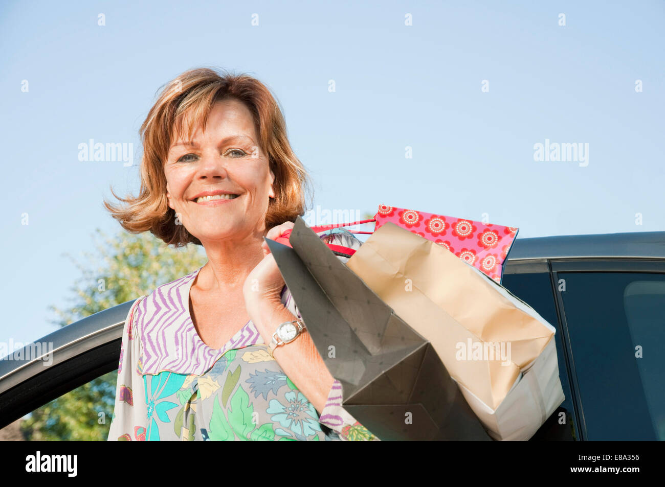 Ältere Frau ins Auto mit Einkaufstüten Stockfoto