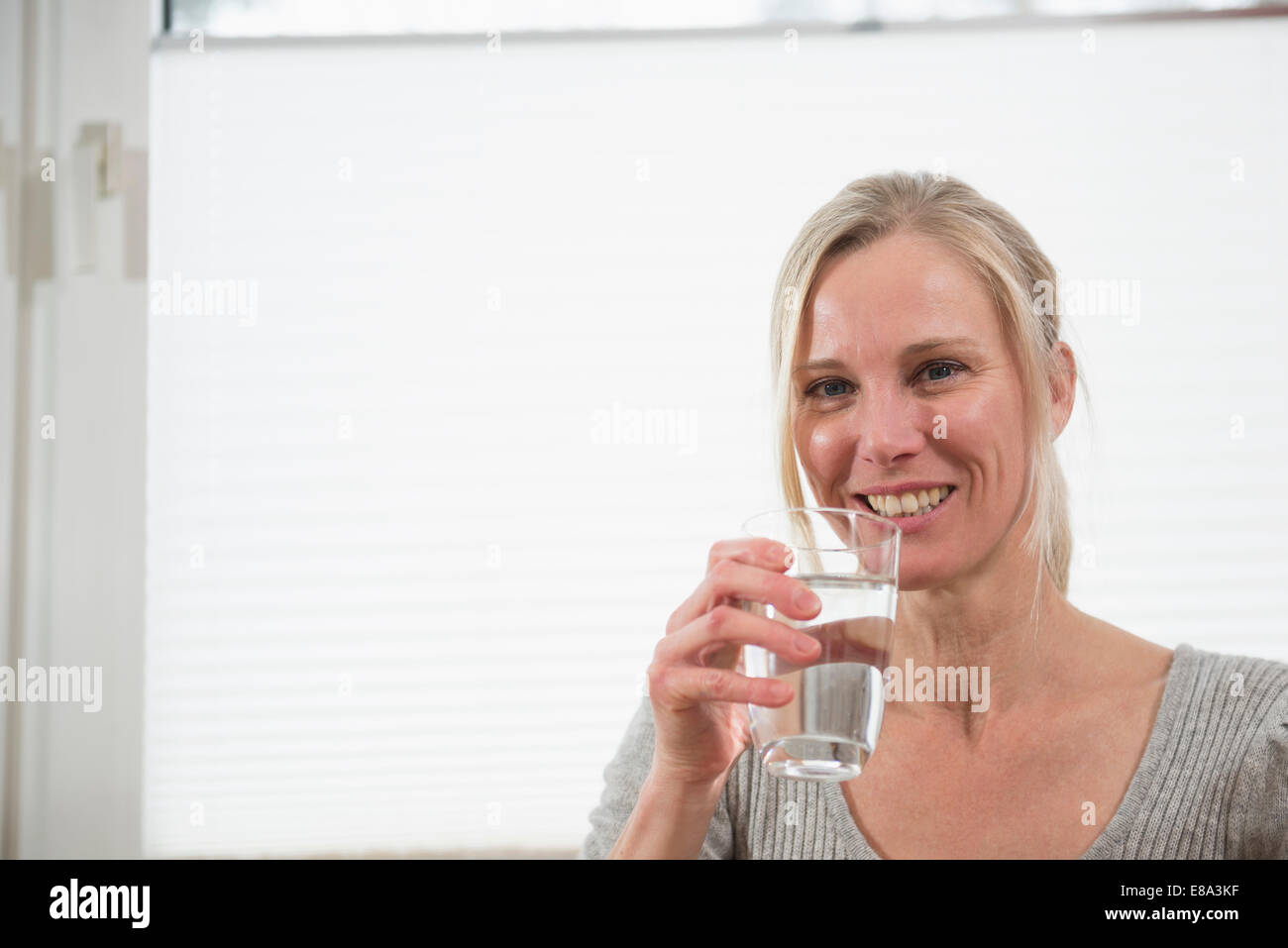 Porträt Frau mit Glas Wasser, Lächeln Stockfoto