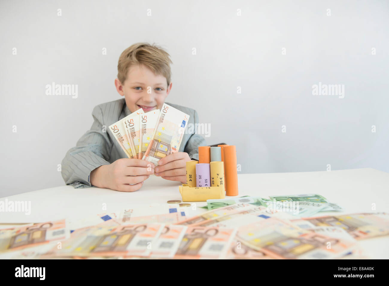 Junge mit Münzrollen und Papiergeld, Lächeln, Porträt Stockfoto