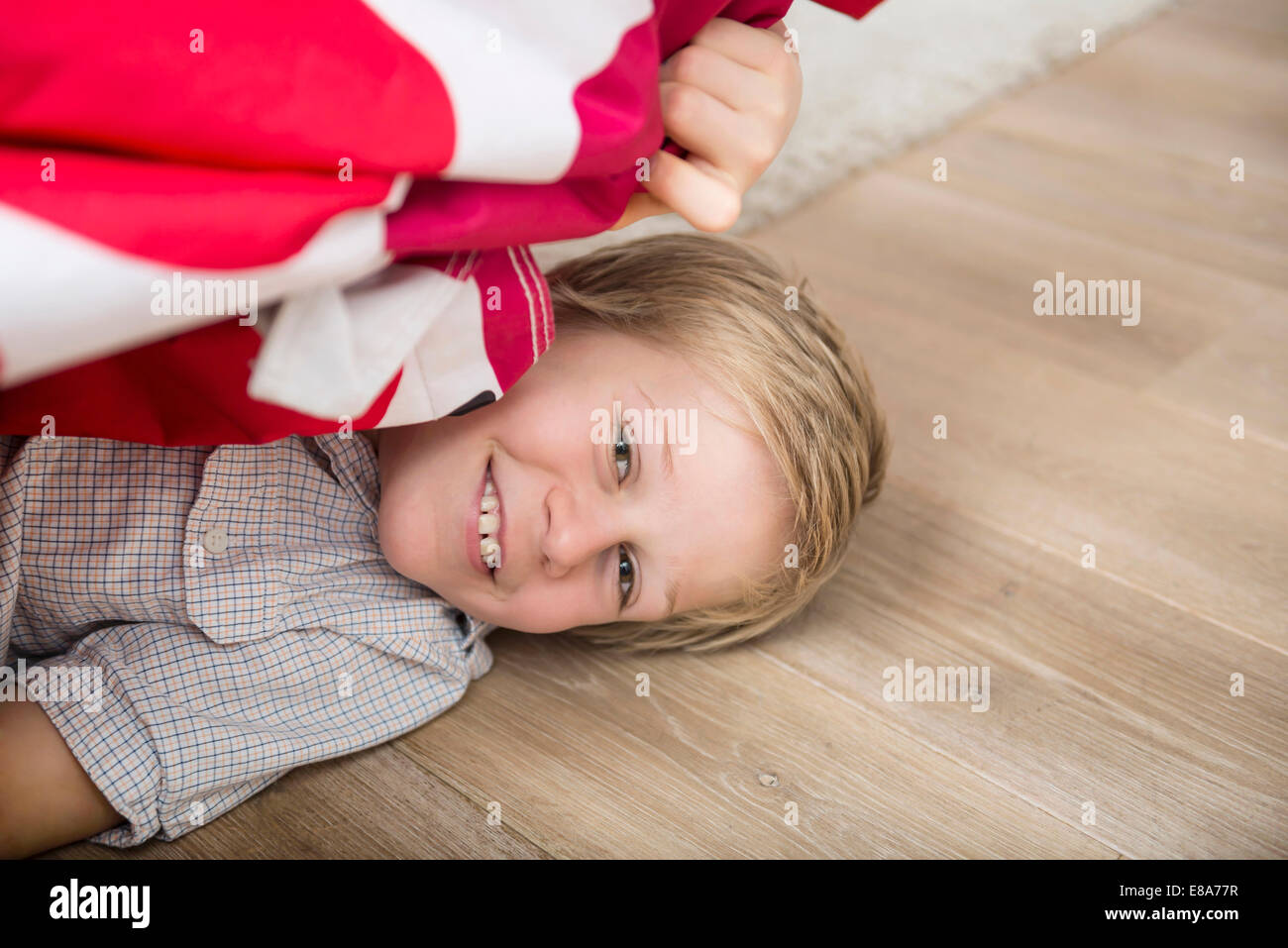 Junge versteckt unter Bett Stockfoto