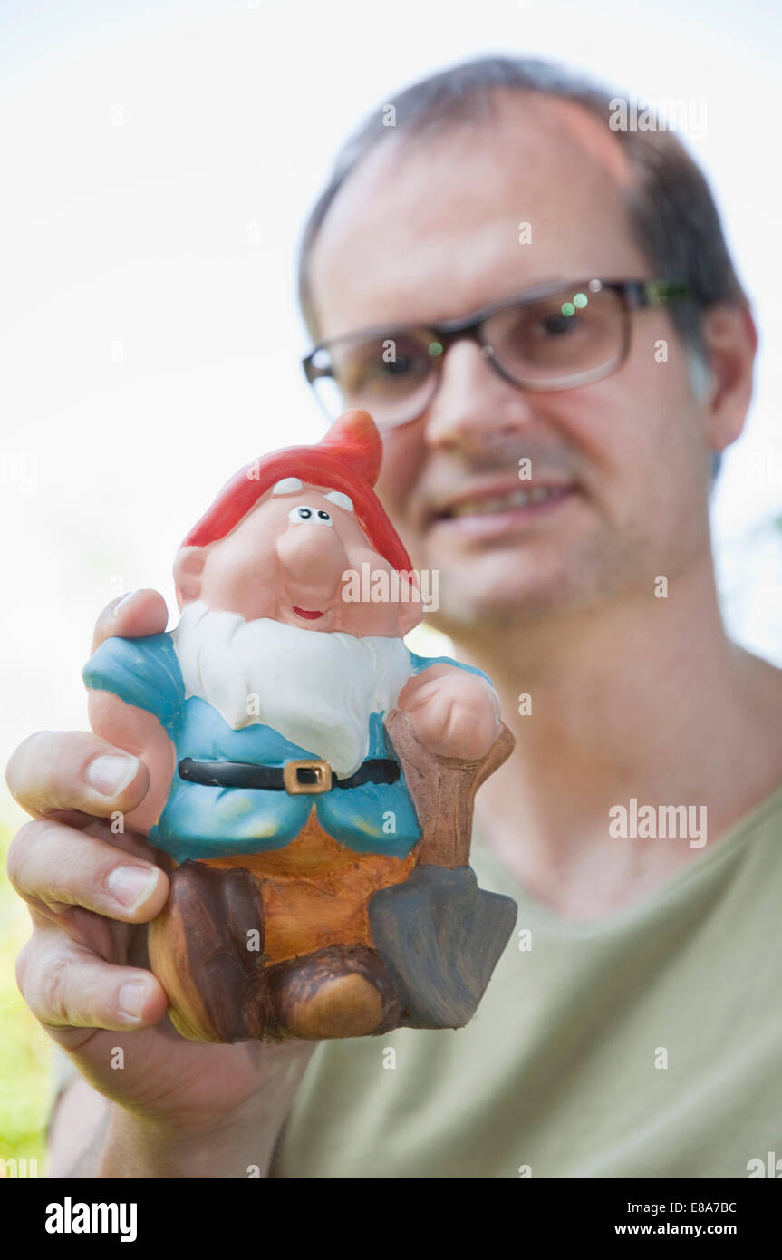 Reifer Mann halten Gartenzwerg, Lächeln, Porträt Stockfoto
