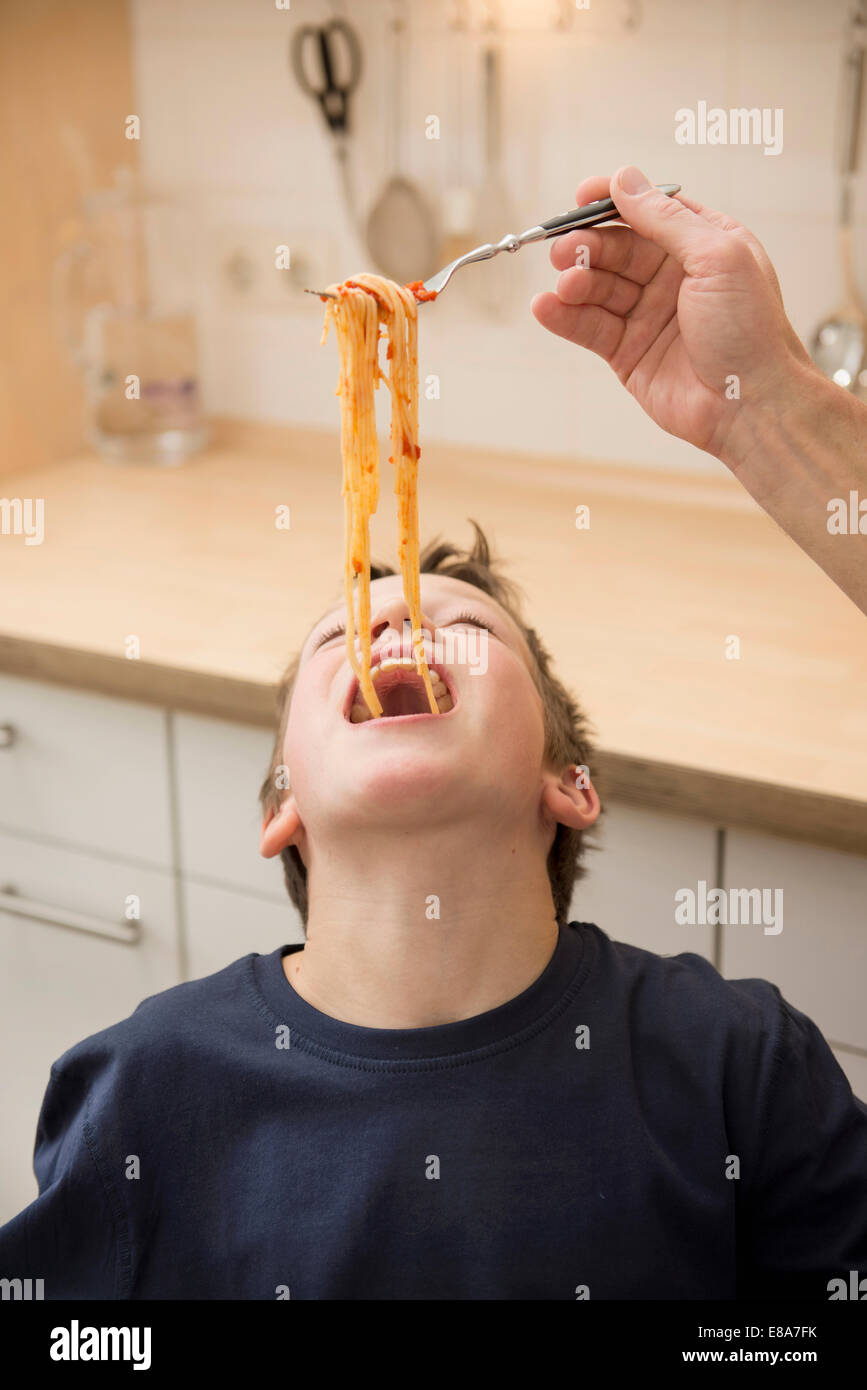 Vater Fütterung Sohn mit spaghetti Stockfoto