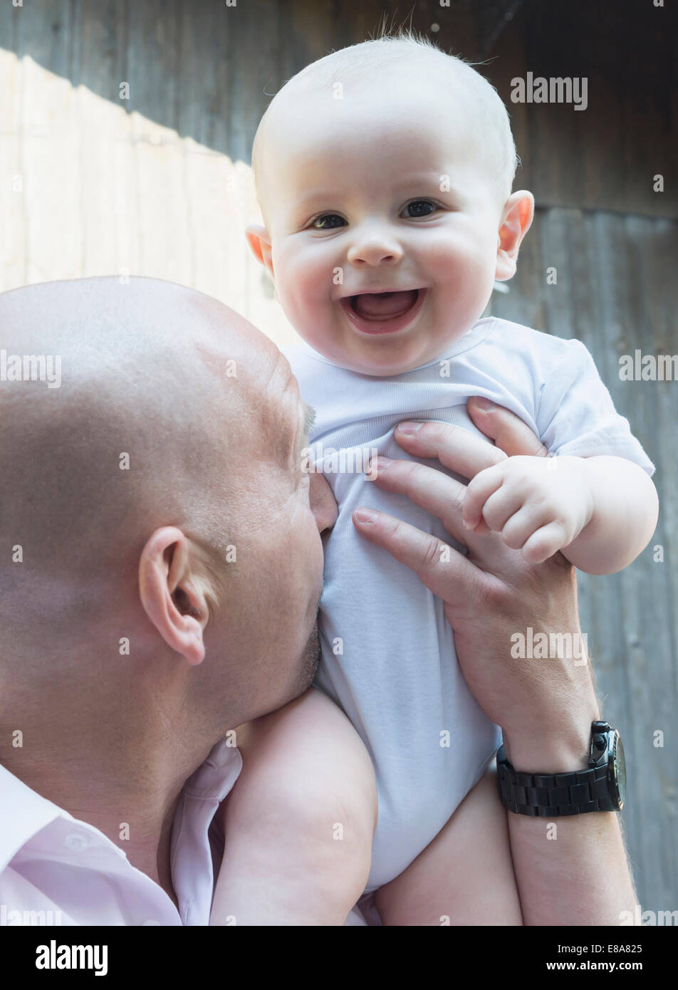 Vater hält Baby Sohn stolz Lachen glücklich Stockfoto