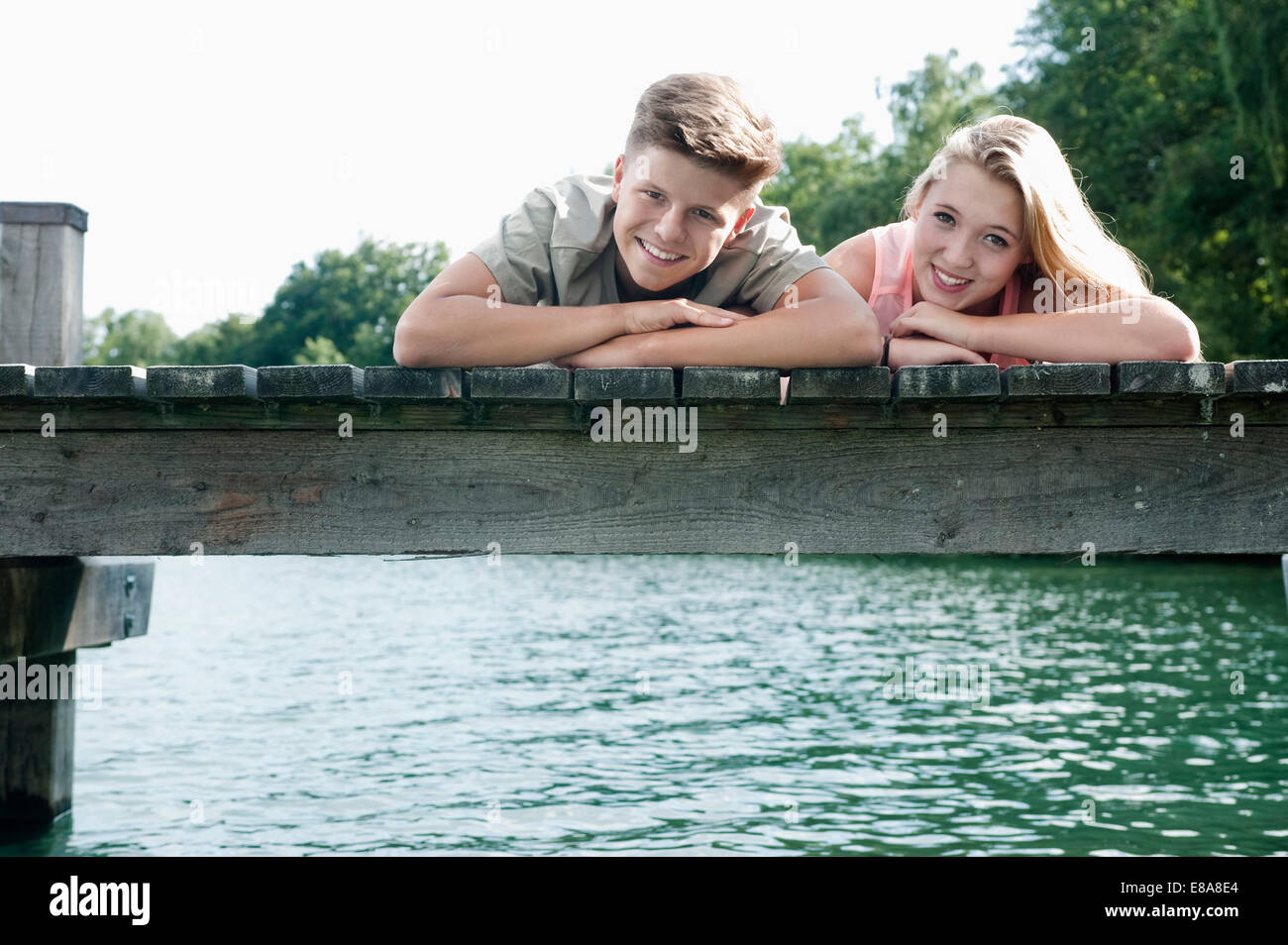 Teenager-paar liegen nebeneinander auf einem Steg am See Stockfoto