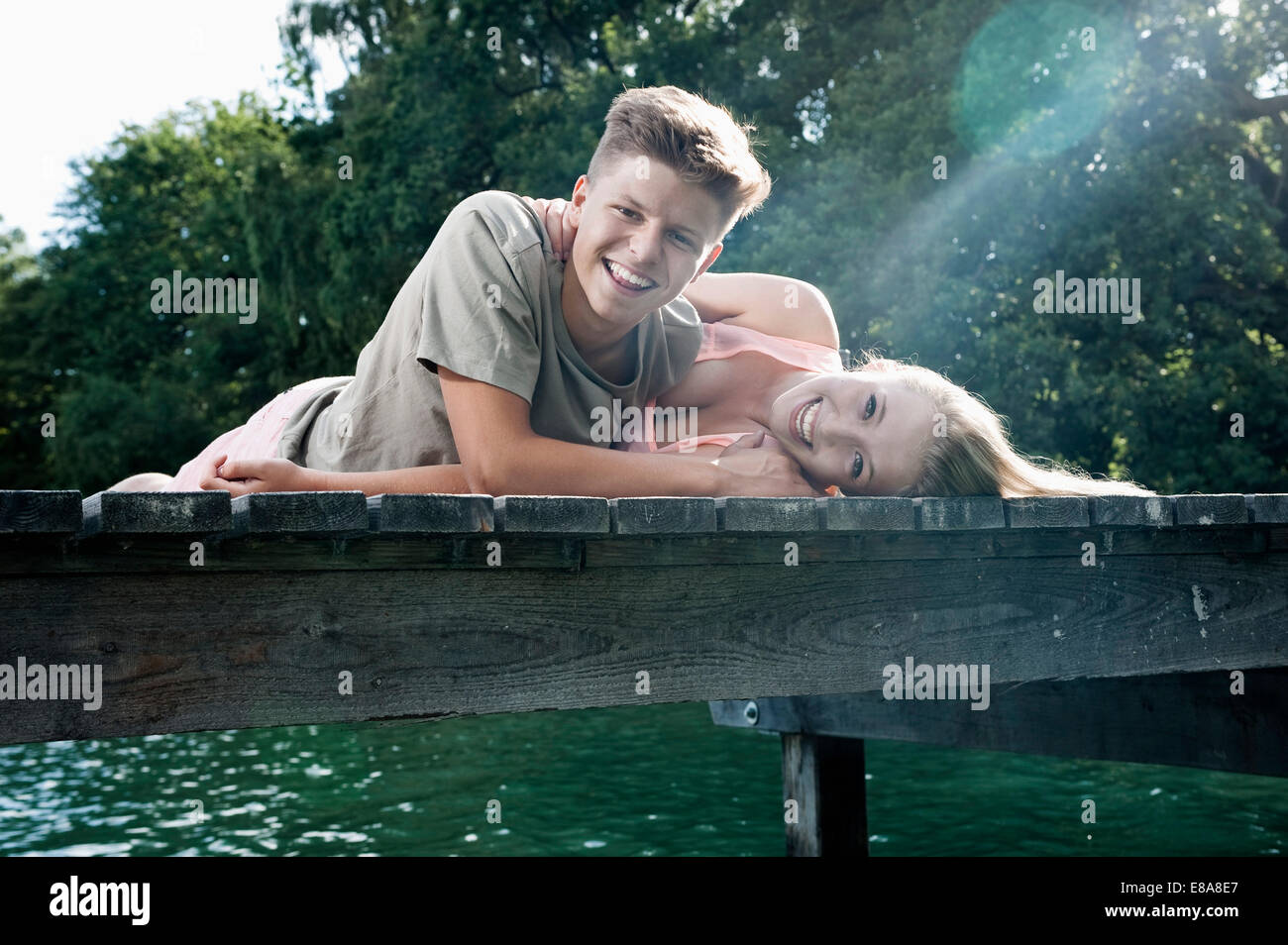 Teenager-paar liegen auf einem Steg am See Stockfoto