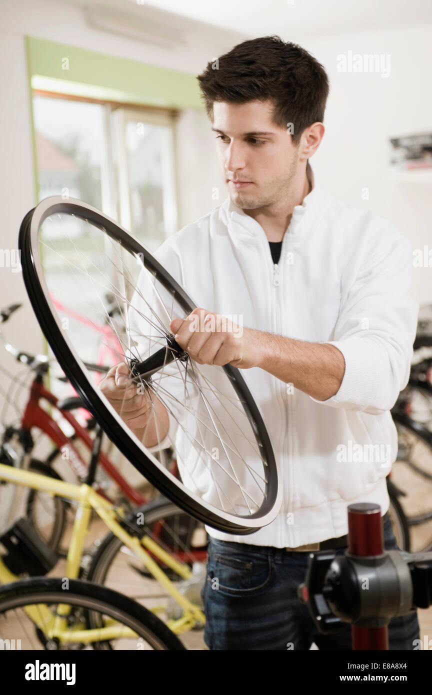 Junger Mann arbeitet an Fahrradreifen Stockfoto