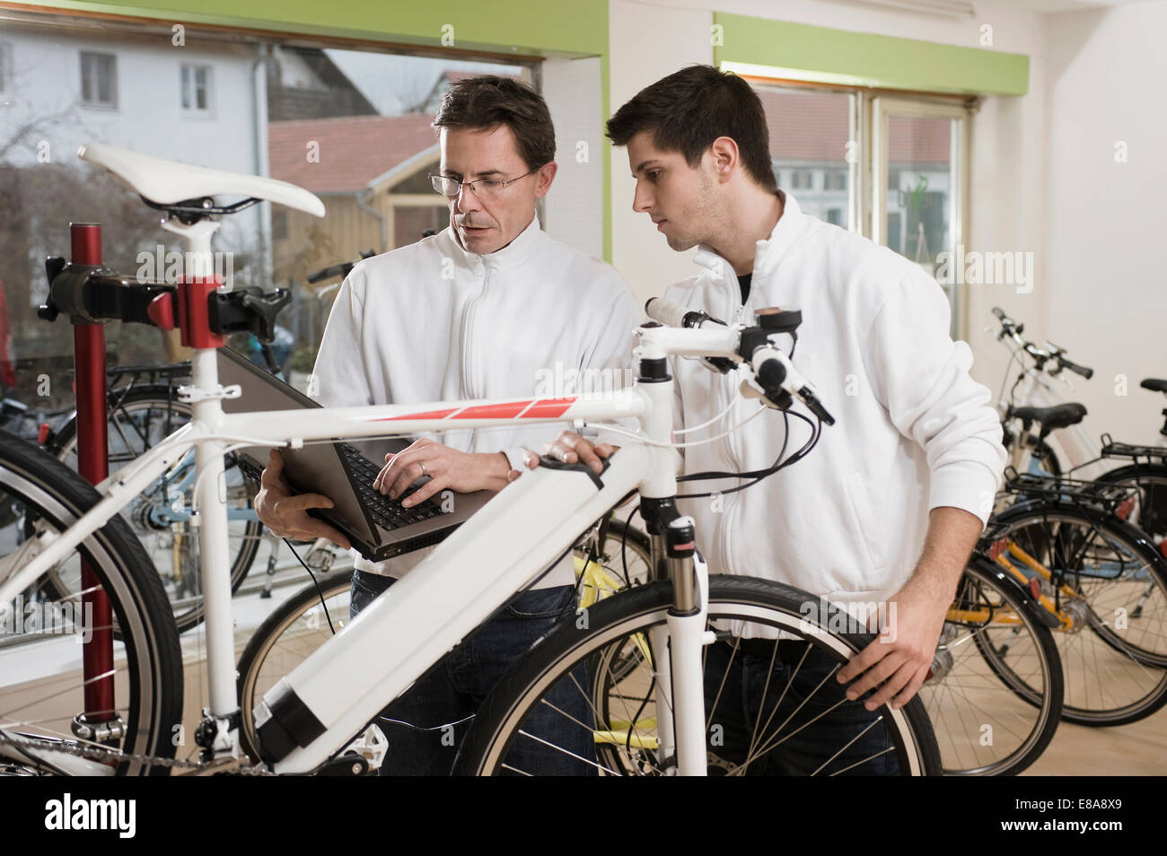 Mechanik, Elektro-Fahrrad mit Laptop testen Stockfoto