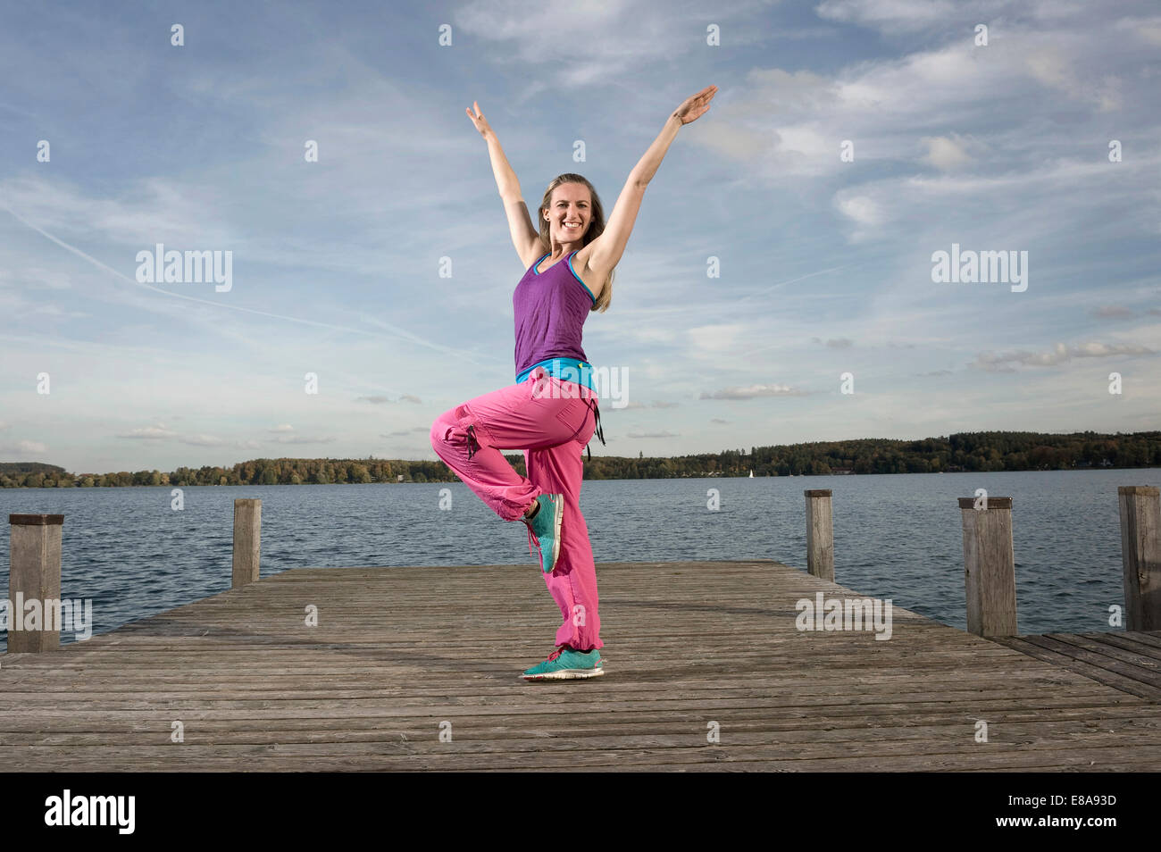 Frau tanzt Zumba auf Steg, Woerthsee, Bayern, Deutschland Stockfoto