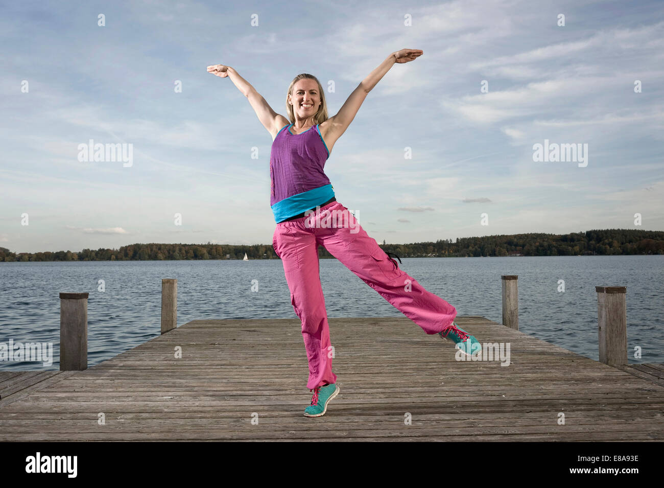 Frau tanzt Zumba auf Steg, Woerthsee, Bayern, Deutschland Stockfoto