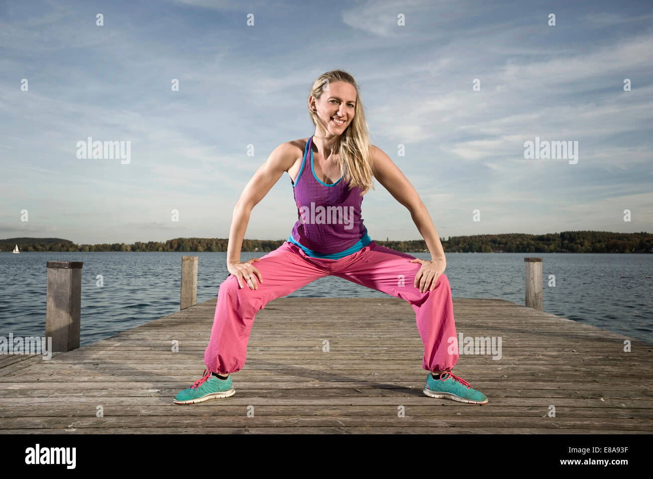 Frau tanzt Zumba auf Steg, Woerthsee, Bayern, Deutschland Stockfoto