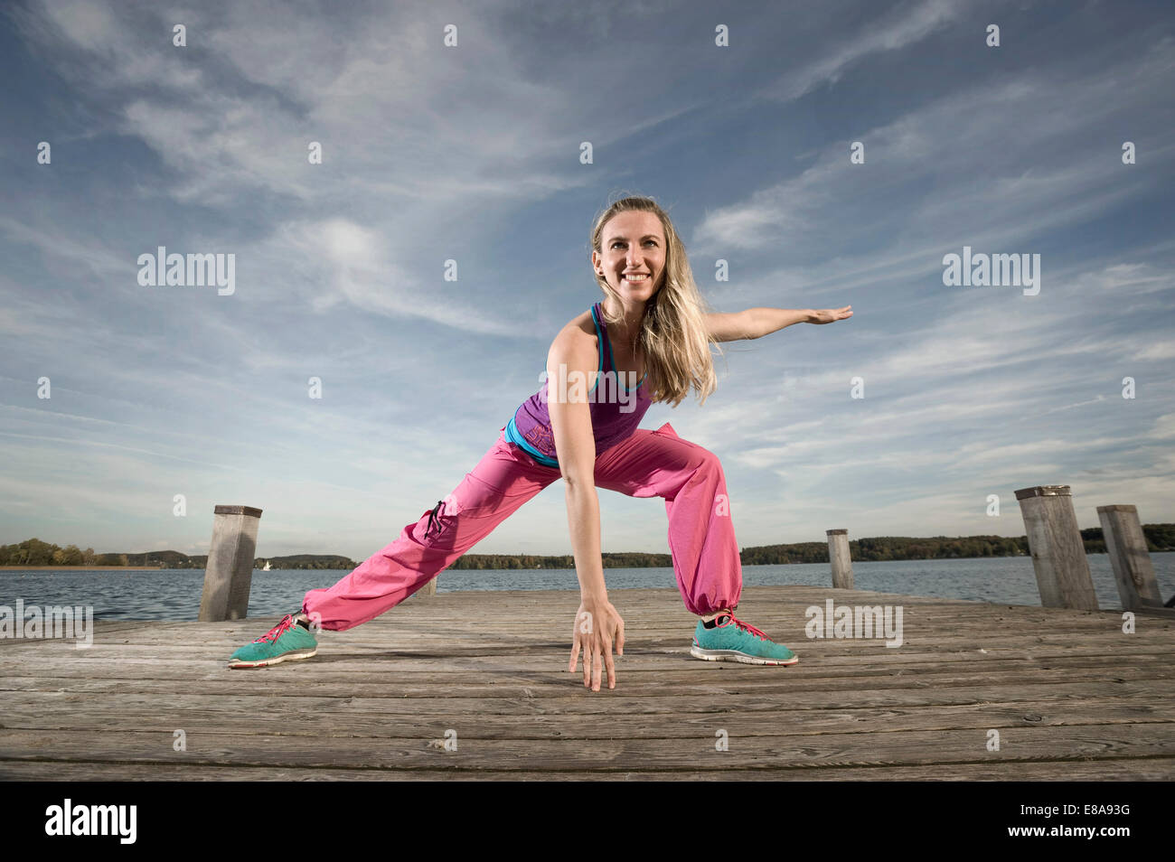 Frau tanzt Zumba auf Steg, Woerthsee, Bayern, Deutschland Stockfoto