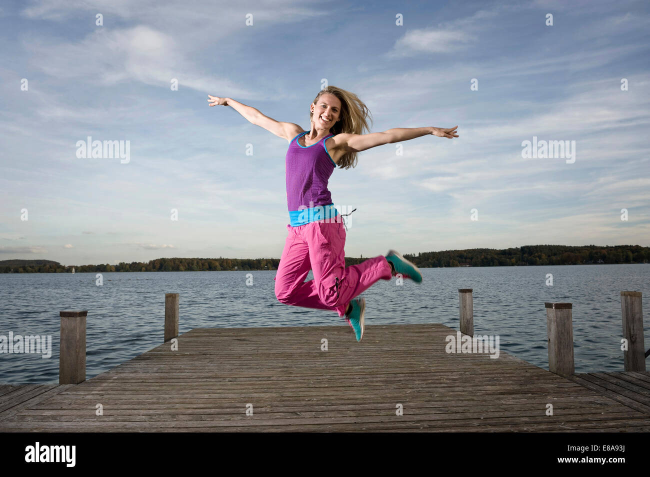 Frau tanzt Zumba auf Steg, Woerthsee, Bayern, Deutschland Stockfoto