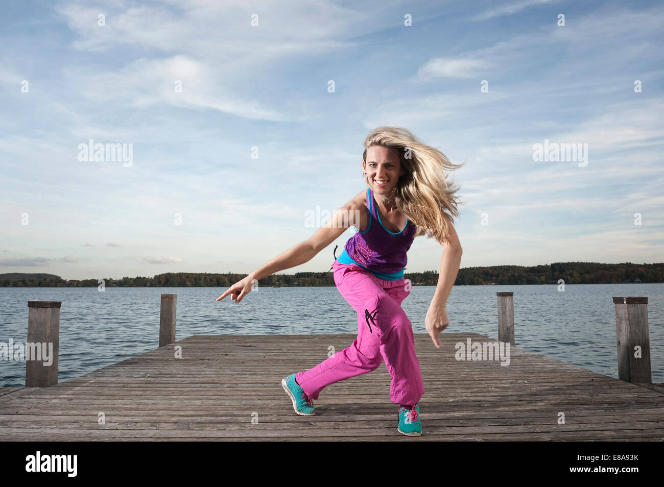 Frau tanzt Zumba auf Steg, Woerthsee, Bayern, Deutschland Stockfoto