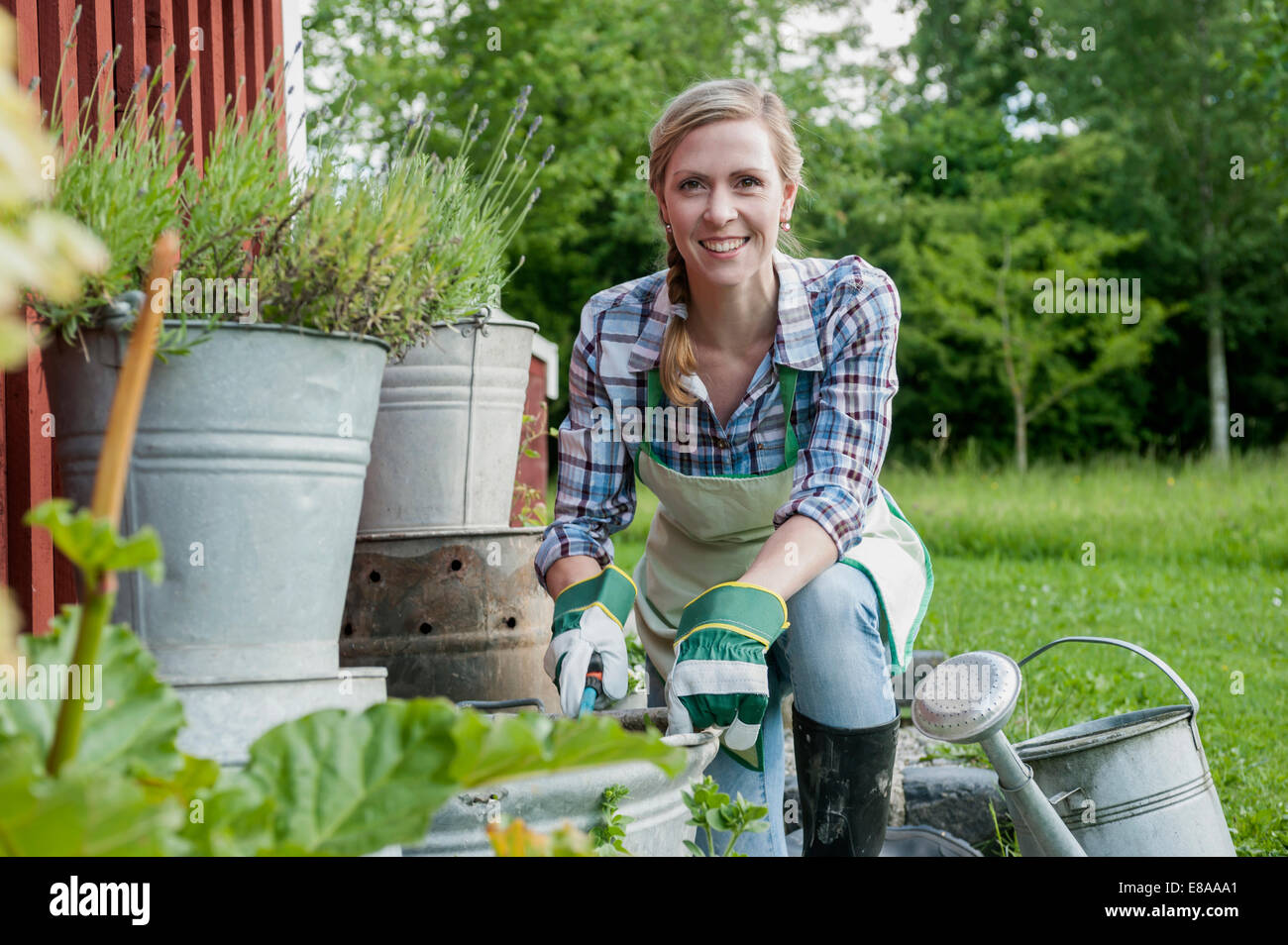 Junge Frau im Garten lächelnd Stockfoto