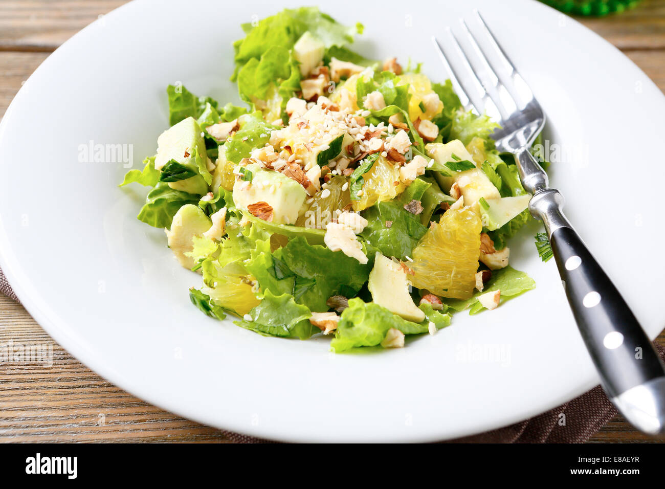 Salat mit Avocado, Salat, Orange und Nüssen auf einer weißen Schüssel essen Nahaufnahme Stockfoto