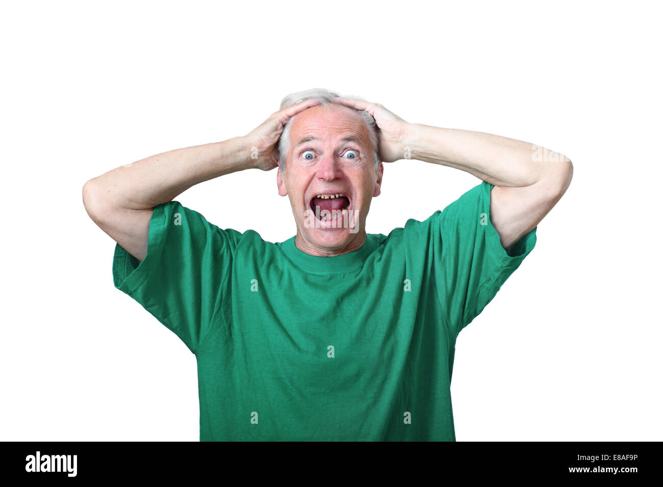 Senior woman umklammerten seine Hände auf den Kopf und schreit mit einem Ausdruck der Panik auf seinem Gesicht isoliert auf weißem Hintergrund Stockfoto