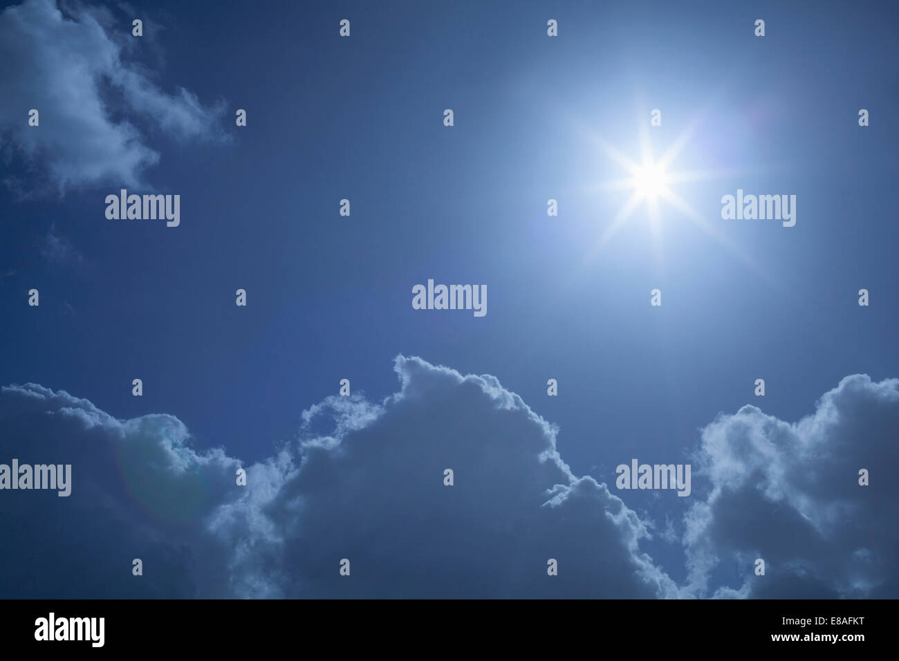 Sunburst im blauen Himmel über Wolken Stockfoto