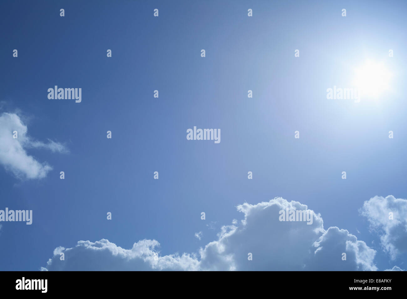 Sunburst im blauen Himmel über Wolken Stockfoto