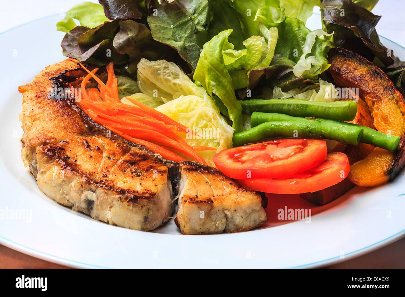 Gegrilltes Lachssteak mit verschiedenem Gemüse auf weißen Teller Stockfoto