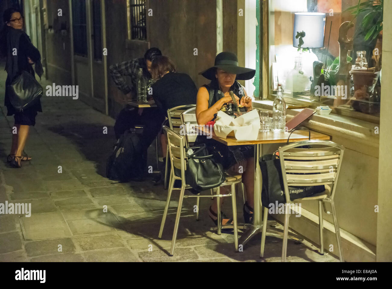 Eine Frau allein in einem kleinen Restaurant in Venedig Stockfoto