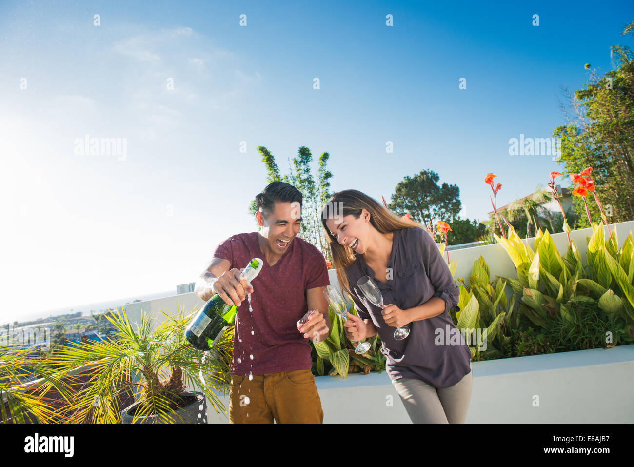 Paar Eröffnung Champagner in Penthouse-Dachgarten, La Jolla, Kalifornien, USA Stockfoto