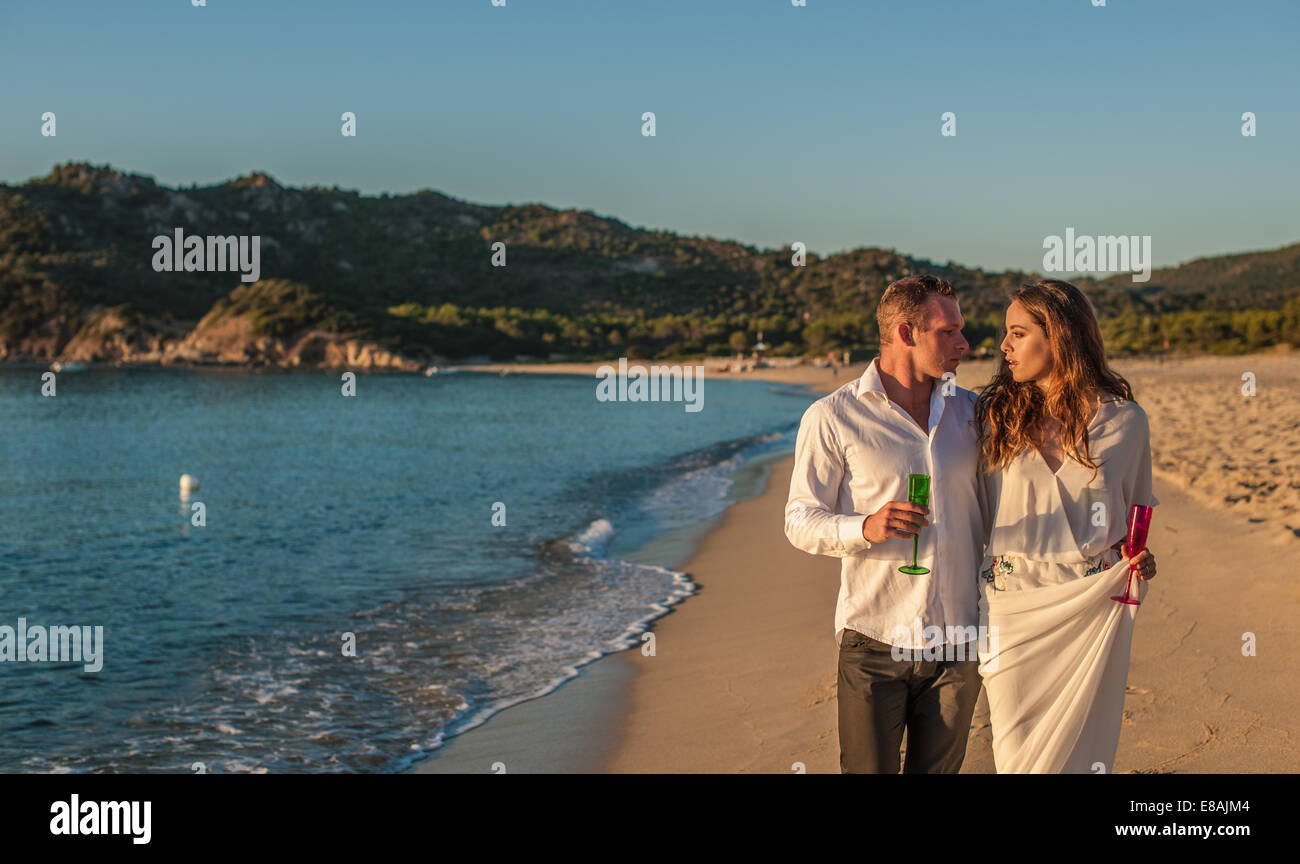 Junges Paar mit Champagner ein Spaziergang am Strand, Castiadas, Sardinien, Italien Stockfoto