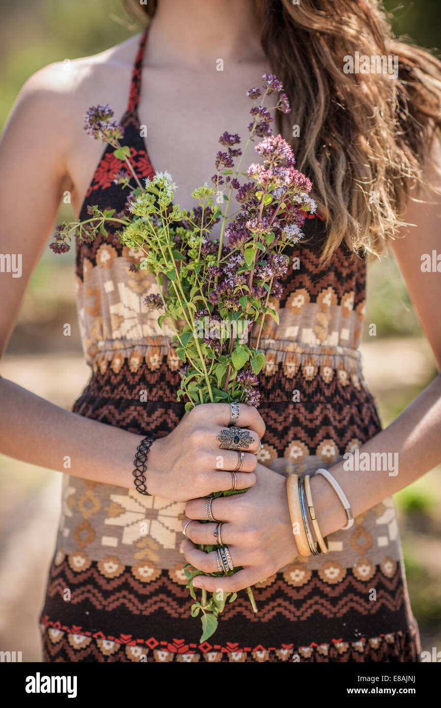 Aufnahme der jungen Frau mit Haufen von Wildblumen beschnitten Stockfoto