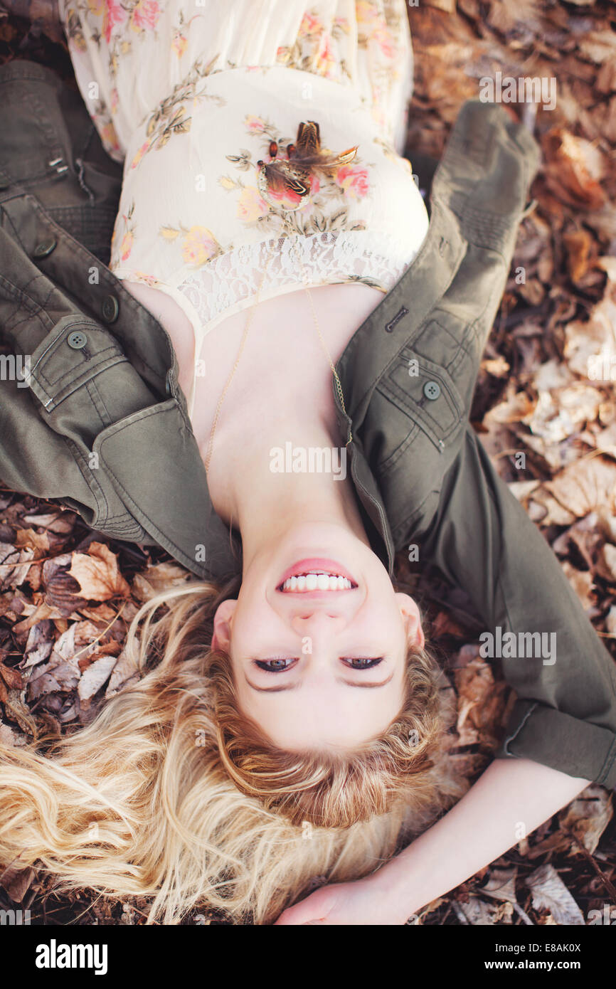 Frau liegt auf Blätter im Herbst Stockfoto