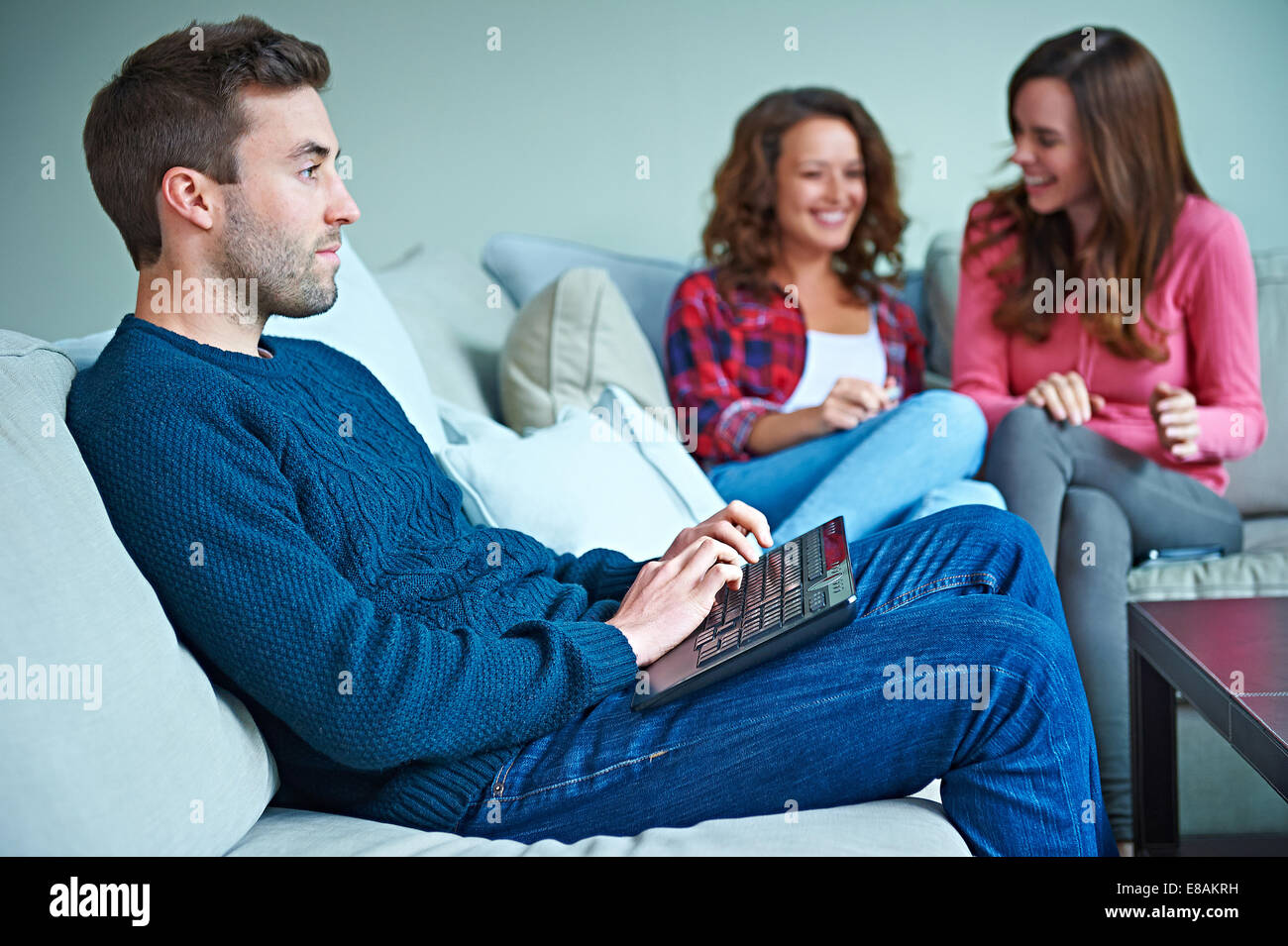 Freunde, die zusammen im Wohnzimmer sitzen Stockfoto