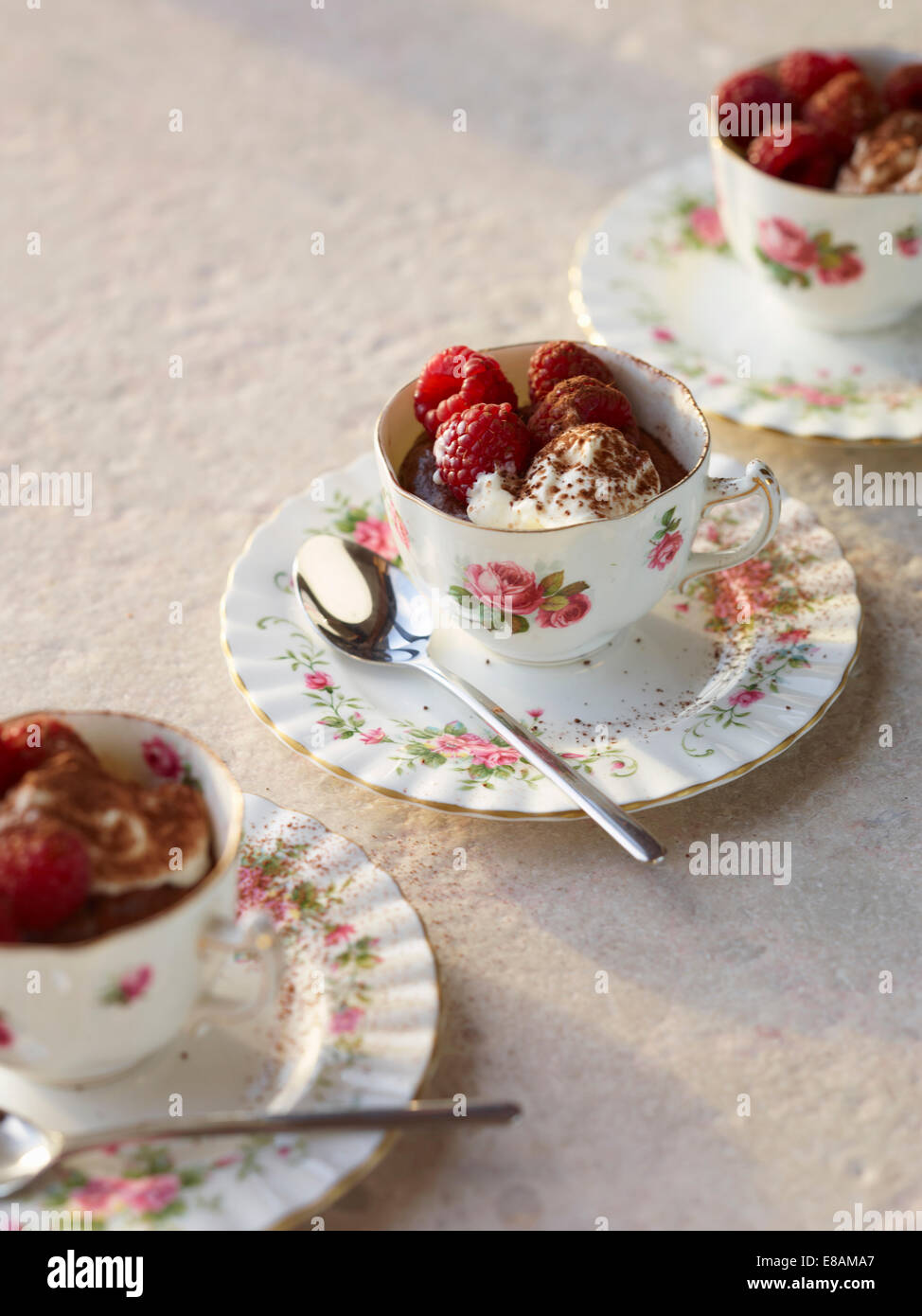 Schokoladenmousse mit Himbeeren und Sahne in Vintage Teetassen Stockfoto