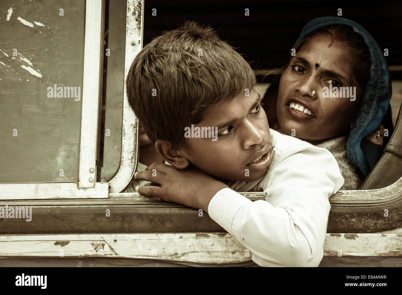 Junge indische Reisende mit ihrer Mutter nach draußen von einem Busfenster Stockfoto