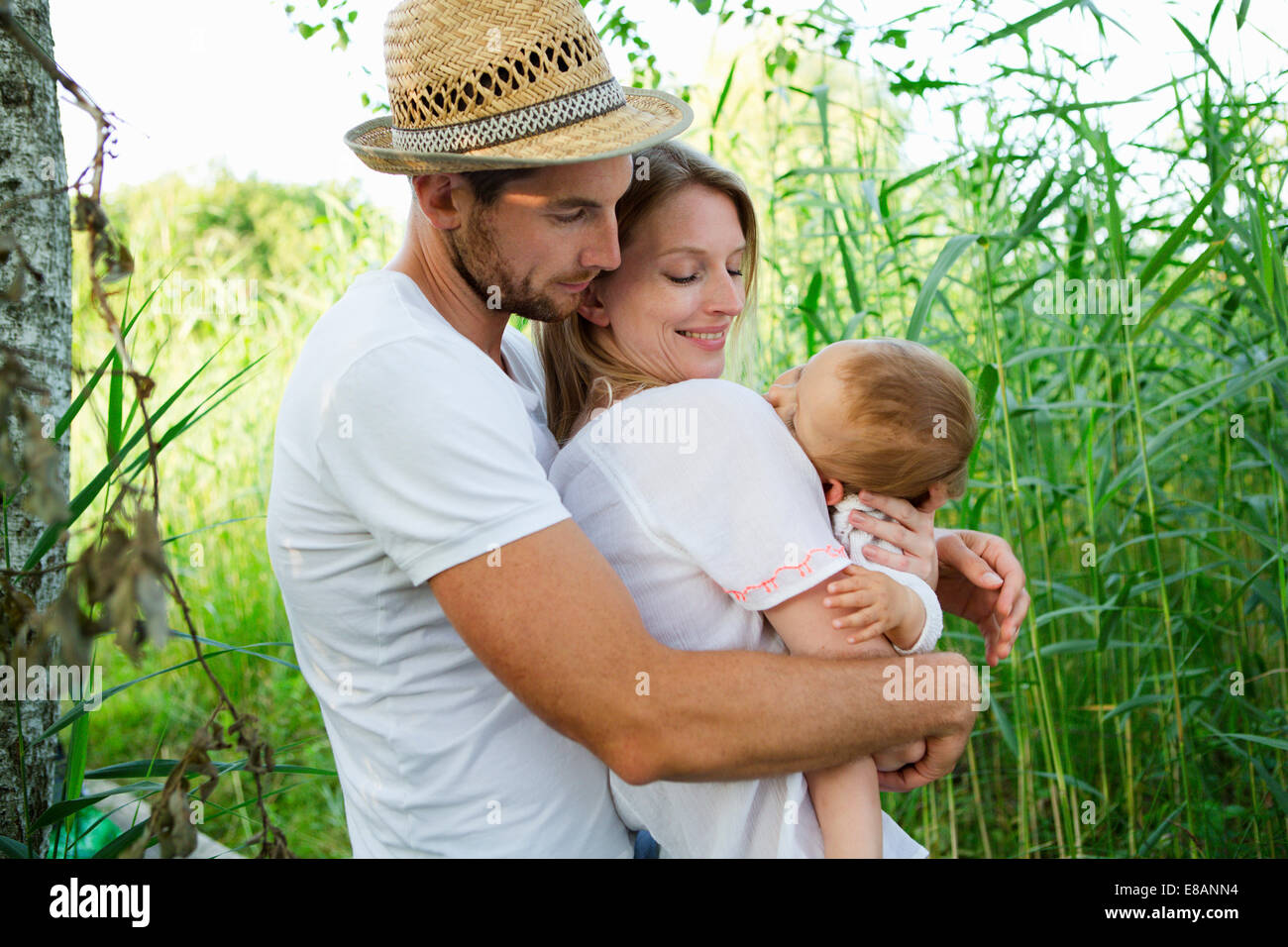 Mitte erwachsenes paar und Tochter mit Arme umeinander im Schilf Stockfoto