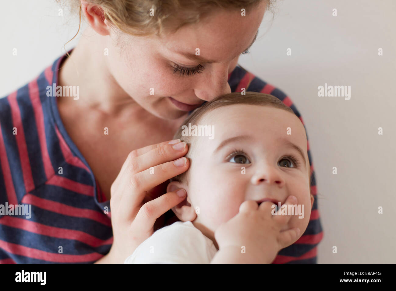 Mutter kuschelte Baby Boy am Kopf Stockfoto