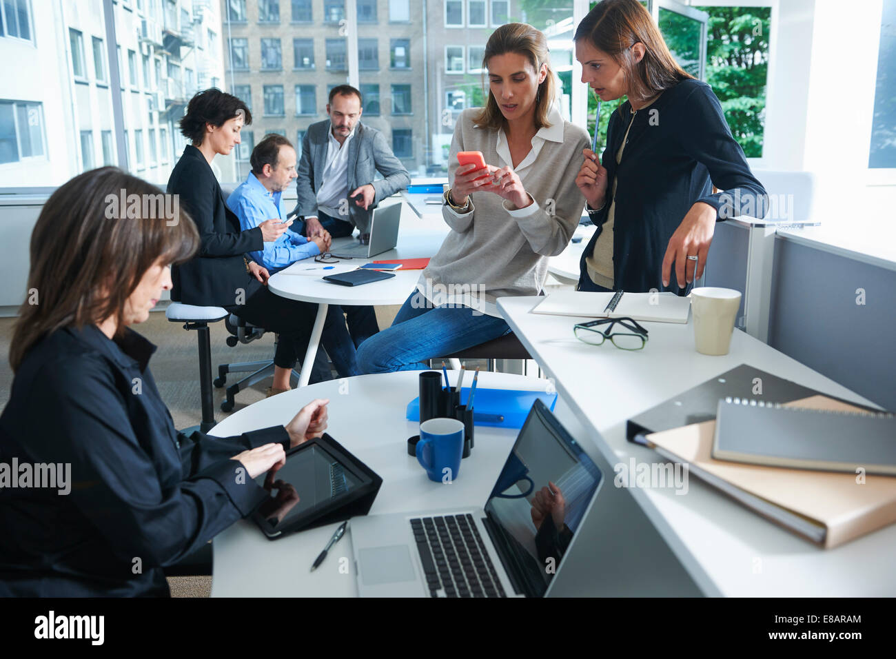 Sechs Unternehmerinnen und Unternehmern im geschäftigen Büro arbeiten Stockfoto