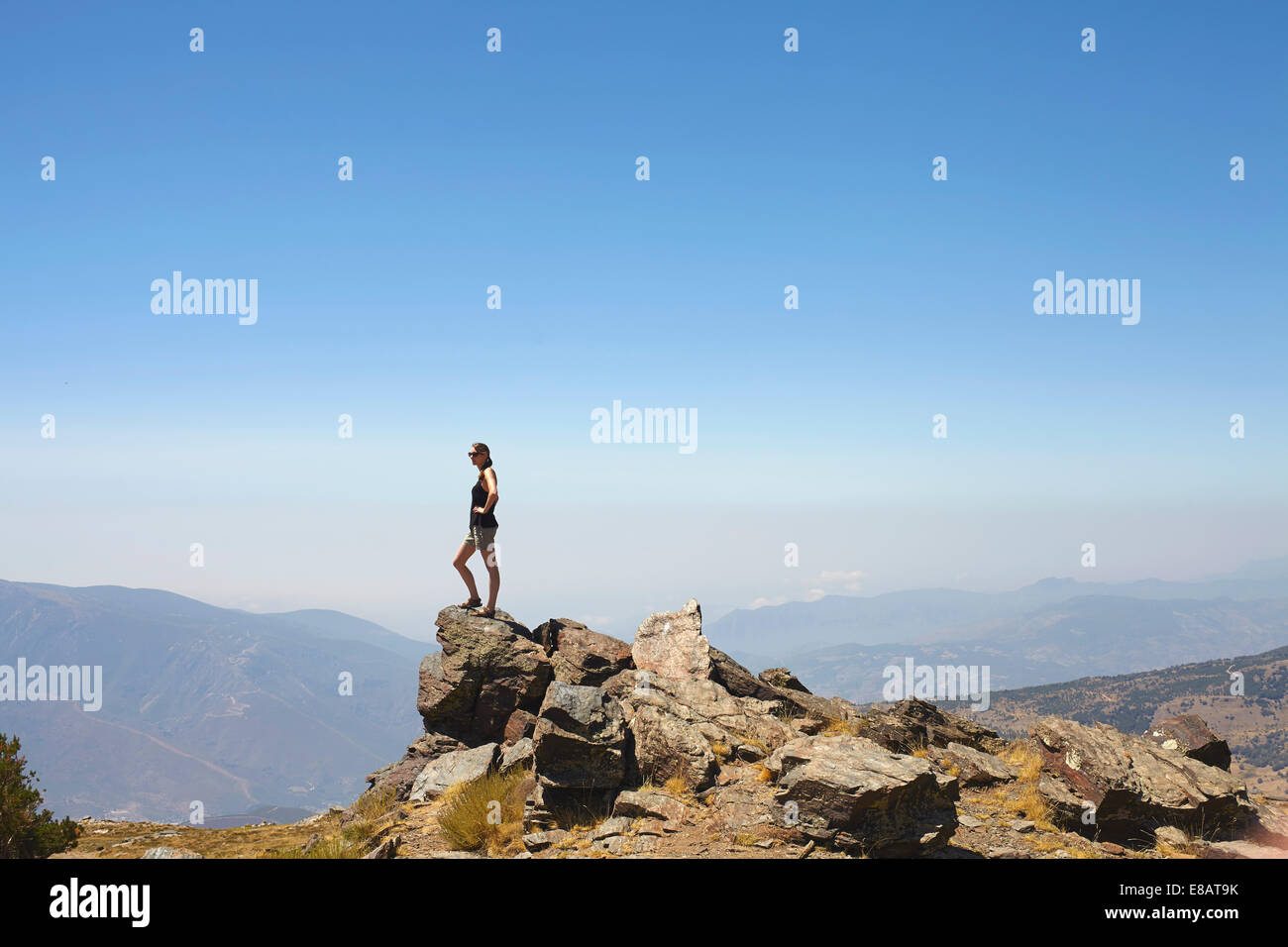 Junge Frau stand oben auf Felsen Blick auf Ansicht, Sierra Nevada, Granada, Andalusien Stockfoto