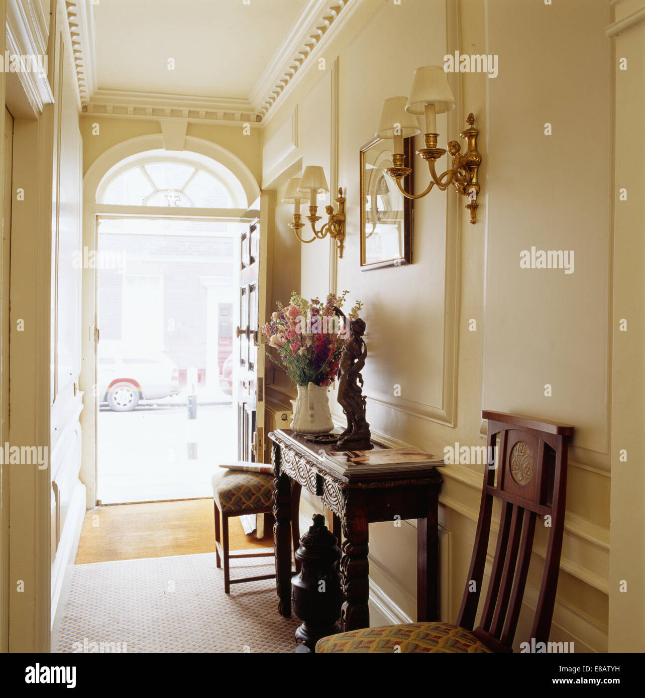 Antike Konsole Tisch und Stühle im cremefarbenen Stadthaus Halle mit offener Tür Stockfoto