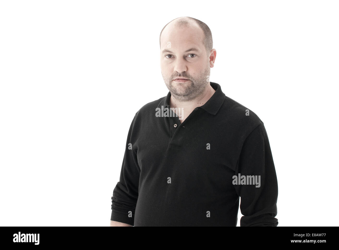 Mitte Schuss eines durchschnittlichen Mannes in ein schwarzes Top mit zurückweichenden Haaren und Stoppeln, Blick in die Kamera mit kein Ausdruck Stockfoto