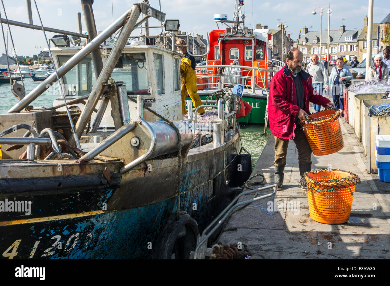 Trawler Fischer bringen Fang in Kunststoff-Körben an Land im Hafen von Barfleur, Basse-Normandie, Frankreich Stockfoto
