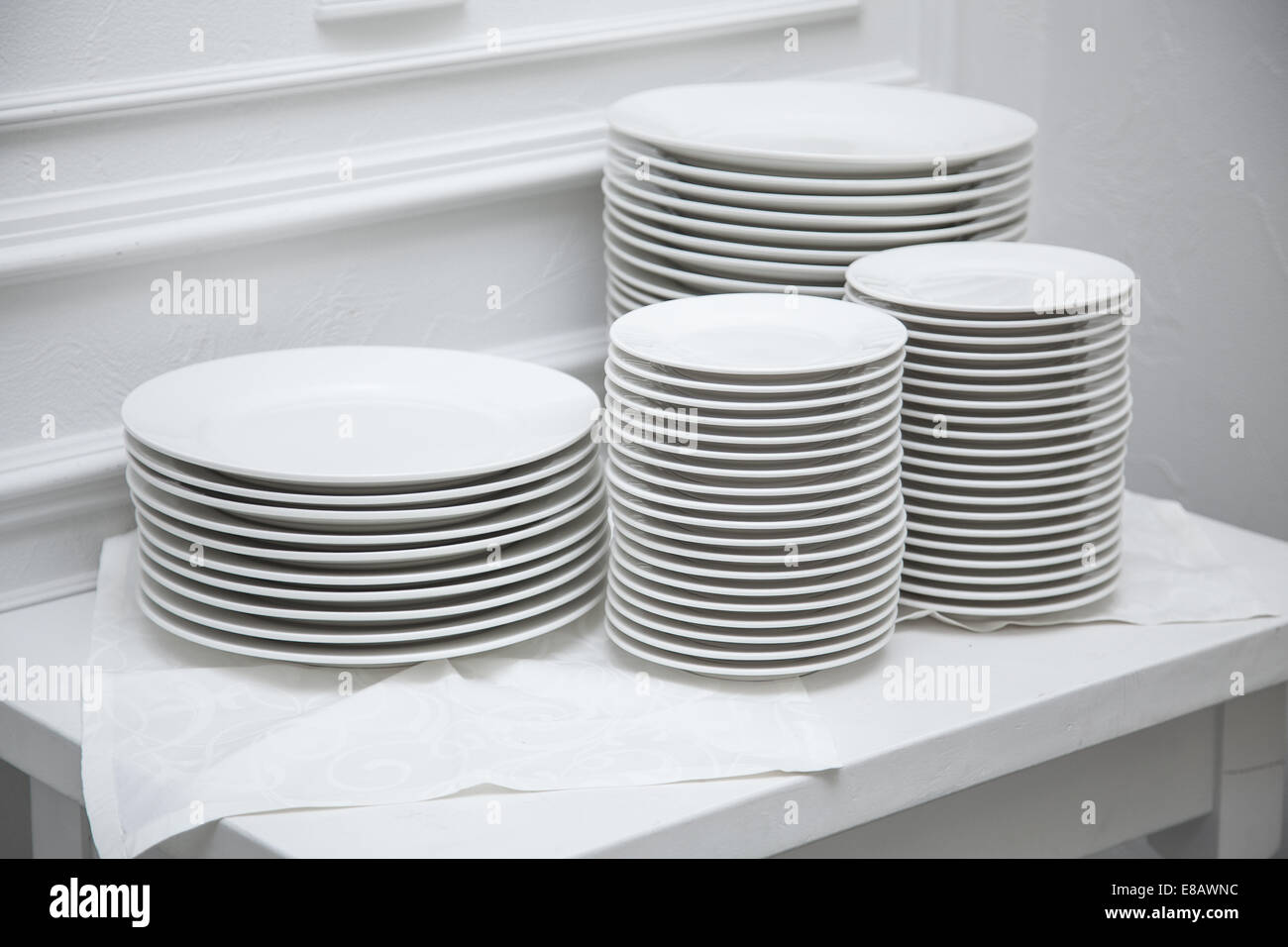 Eingestellt von sauberen Tellern am weißen Tisch im Restaurant. Stockfoto
