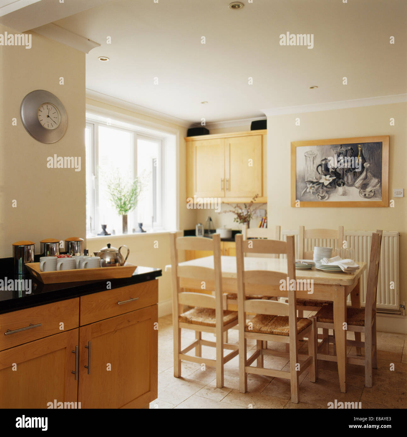 Holztisch und Stühle in Creme Land Küche Esszimmer mit schwarz + weiß Bild an die Wand gemalt Stockfoto