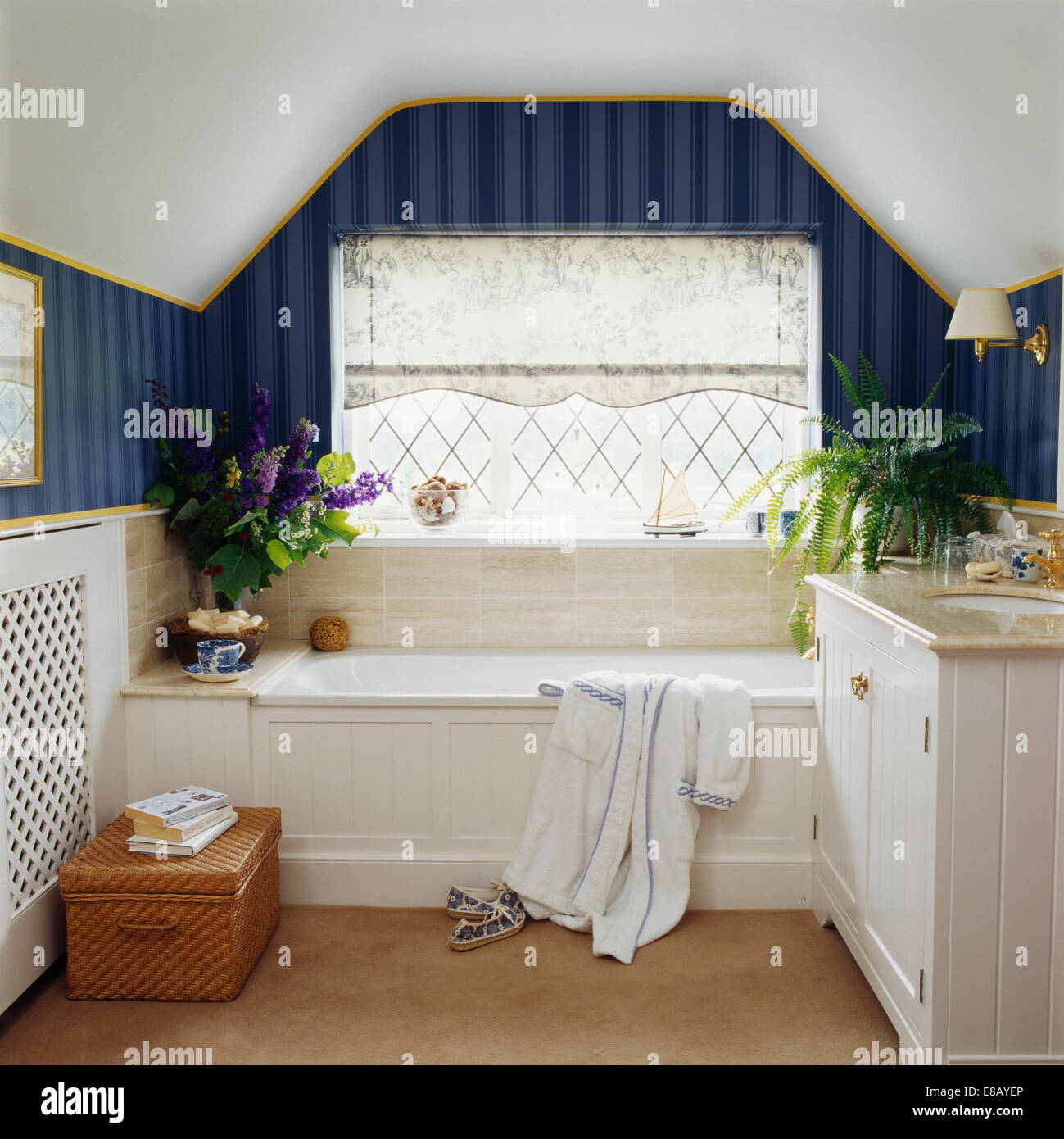 Schiere Blind auf Fenster über Bad im Land Loft Conversion-Schlafzimmer mit dunklen blau gestreifte Tapete Stockfoto