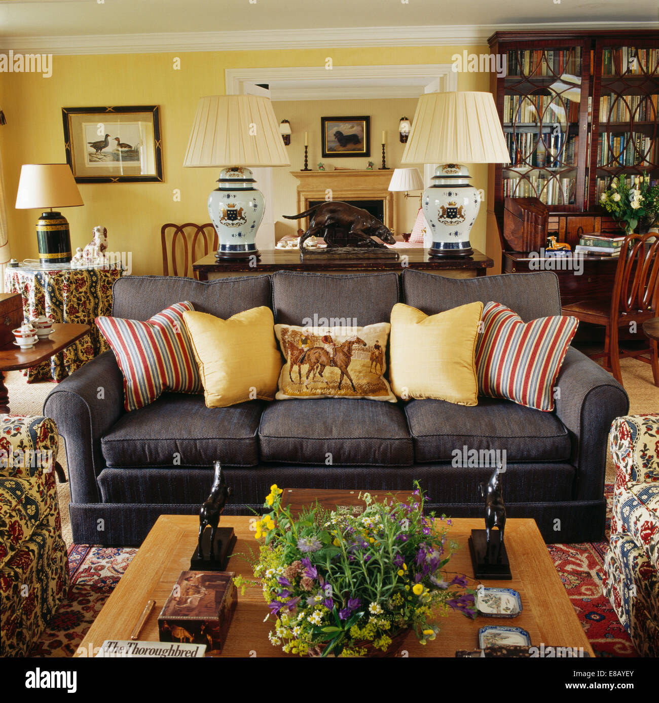 Blasses gelb-gestreiften Kissen auf dunklen grauen Sofa im Wohnzimmer Gelb Land Stockfoto